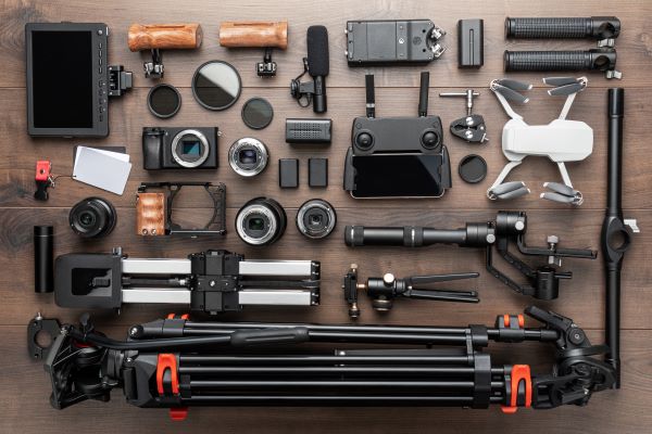 A flat lay of various cameras, drones, and video equipment