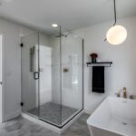 A Modern Bathroom With A Glass Shower And Freestanding Bathtub