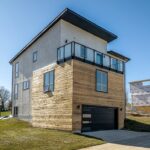 A Modern Home With Wood Siding And A Balcony By Residential Architects