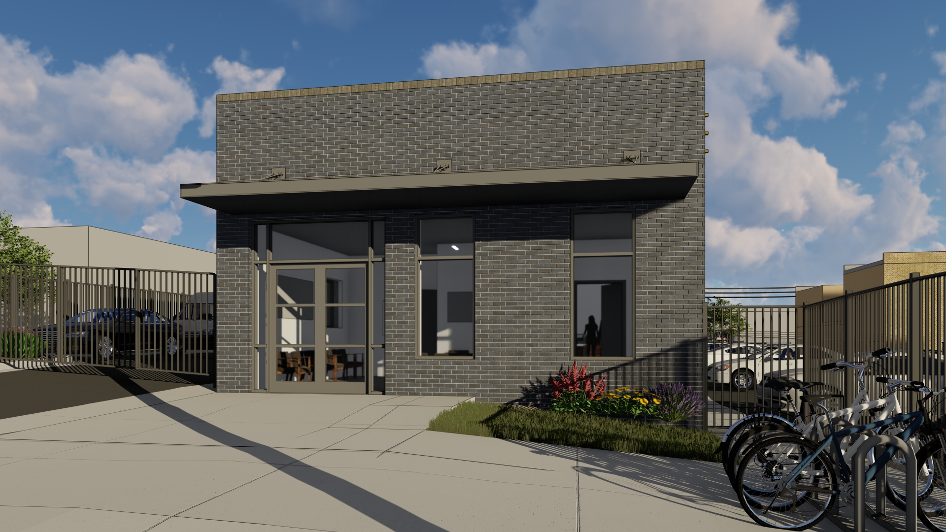 A Gray Brick Building With Large Windows And A Bicycle Rack