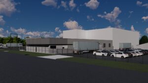 A Large Industrial Building With Trucks And A Parking Lot