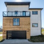 A Modern Residential Home With Wood Siding And A Balcony By Architects