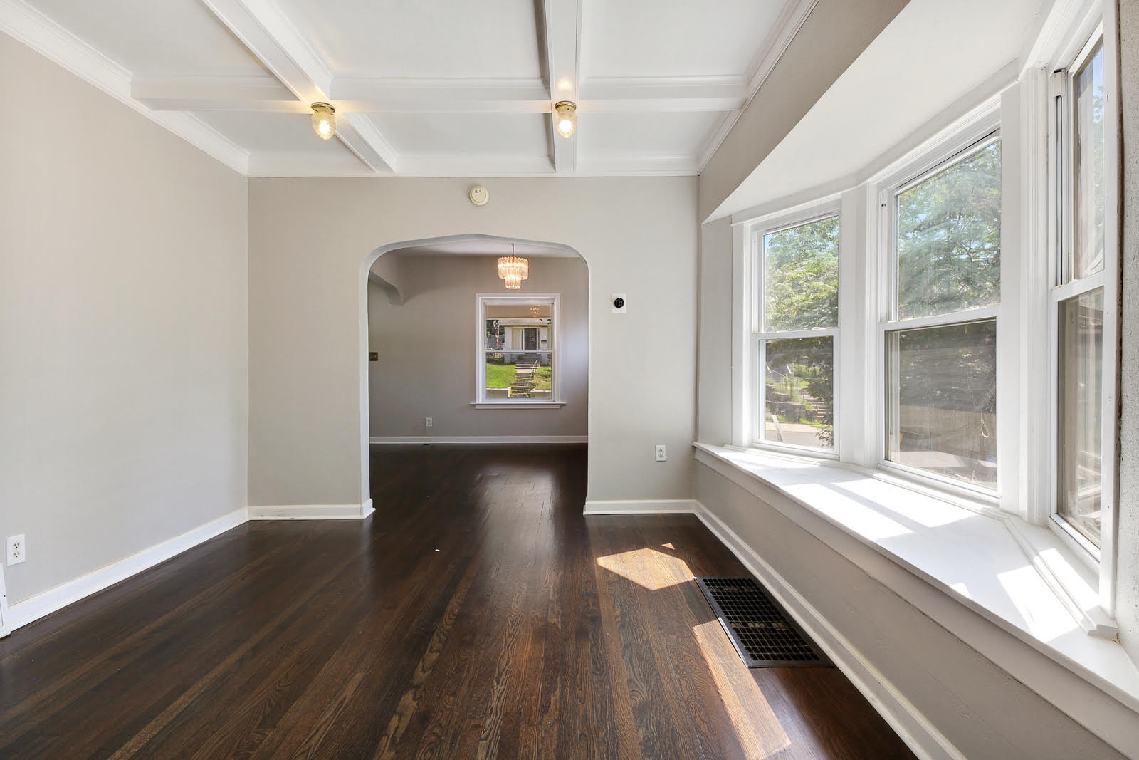 An Empty Room With Hardwood Floors And A Bay Window